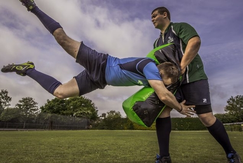 Two men engaged in a soccer match on a grassy field, showcasing teamwork and athleticism.