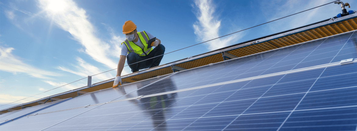 A male civil engineer inspecting a solar panel at a construction site with protective gear