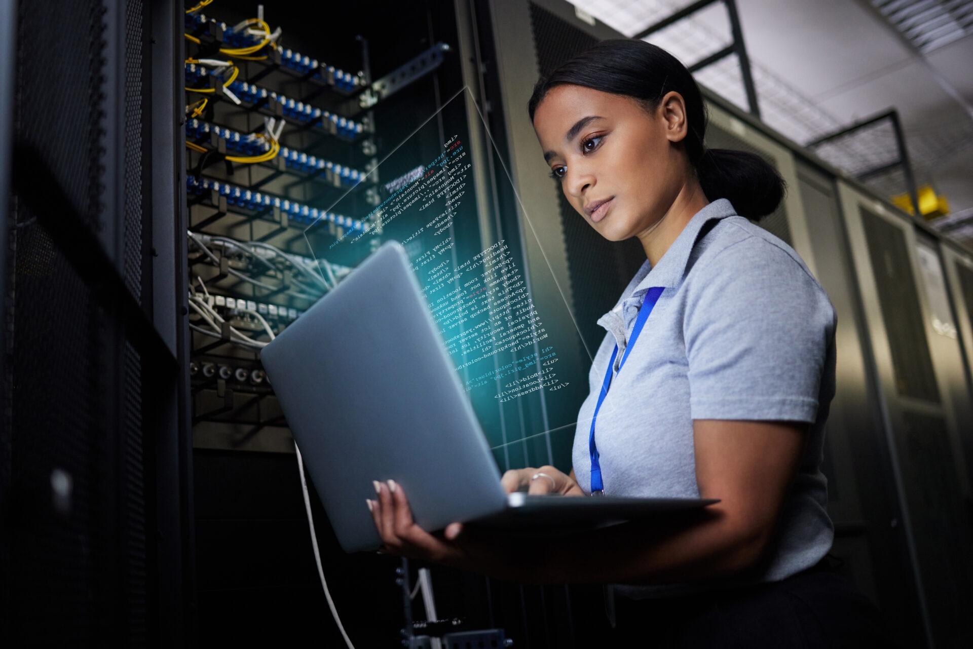 A female systems engineer reviewing code in a laptop connected to a cloud server at night